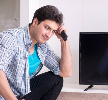 Bozuk televizyonu tamir etmeye çalışan adam