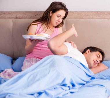 Mutlu bir aile yatakta kahvaltı yapıyor.