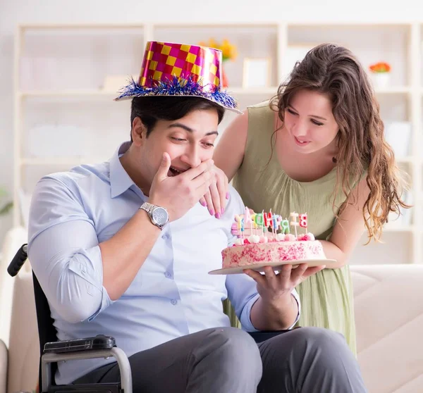 Joven familia celebrando cumpleaños con persona discapacitada —  Fotos de Stock