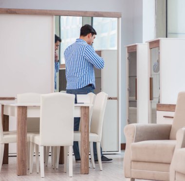 Genç adam mobilya dükkanından alışveriş yapıyor.