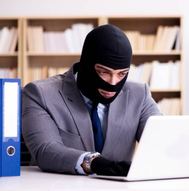 Suçlu iş adamı ofiste kar maskesi giyiyor.