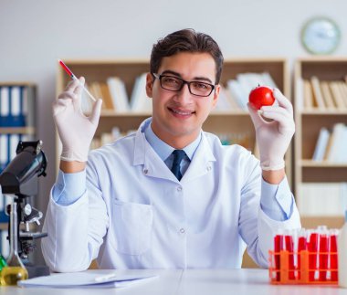 Bilim adamı organik meyve ve sebzeler üzerinde çalışıyor.