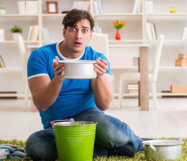 Evdeki adam, komşu sel sızıntısıyla uğraşıyor.