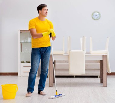 Evi temizleyen adam karısına yardım ediyor.