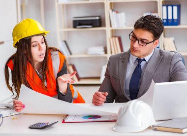 İnşaat ustabaşı çizimleri gözden geçiriyor