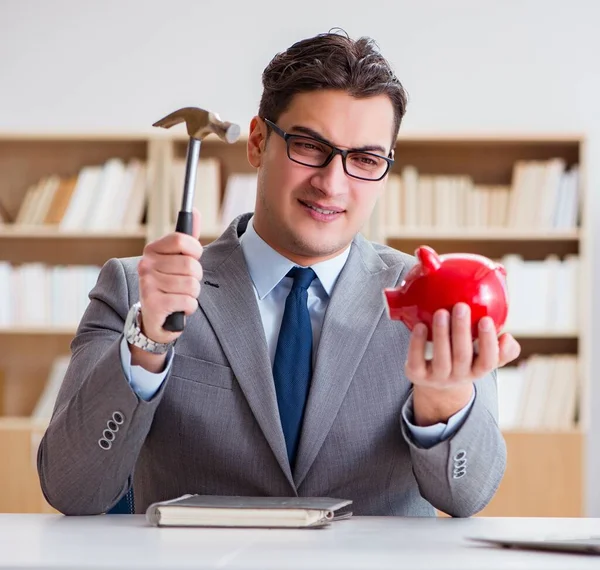 Empresario rompiendo una hucha en la oficina — Foto de Stock