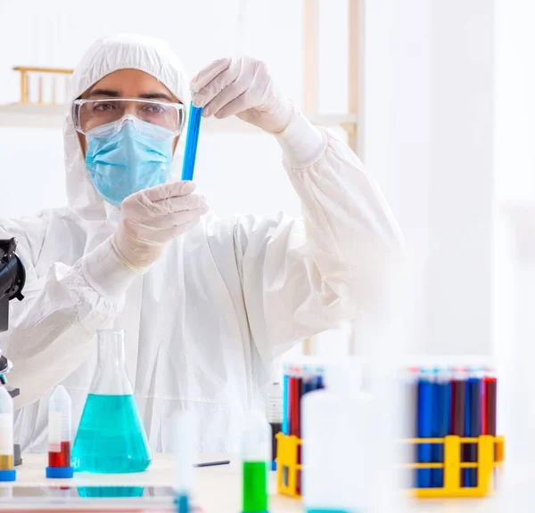 Jovem estudante de química que trabalha em laboratório em produtos químicos — Fotografia de Stock