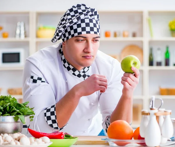 Jonge mannelijke kok werkt in de keuken — Stockfoto