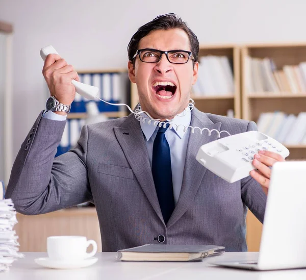 Angry businessman with too much work in office — Stock Photo, Image