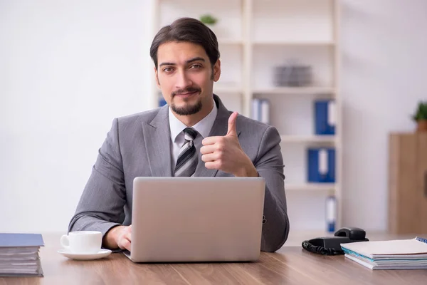 Jovem atraente masculino empregado sentado no local de trabalho — Fotografia de Stock