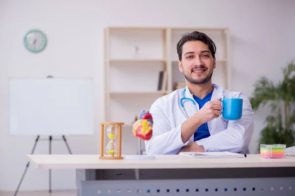 Zaman yönetimi konseptinde genç erkek doktor kardiyolog — Stok fotoğraf