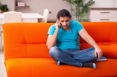 Genç erkek öğrenci salgın sırasında evde oturuyor.