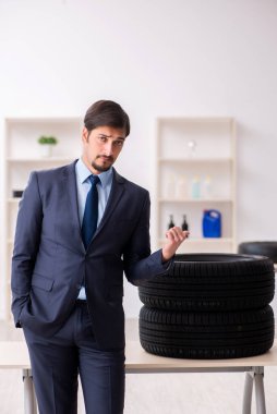 Genç adam ofiste lastik satıyor.