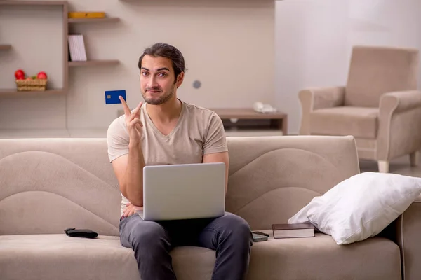 Jongeman die thuis goederen bestelt met een creditcard — Stockfoto