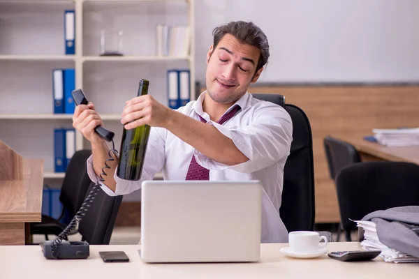 Jeune employé de sexe masculin buvant de l'alcool au bureau — Photo