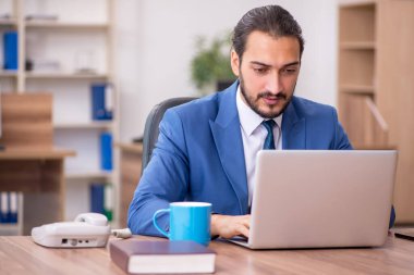 Ofiste çalışan genç bir erkek.