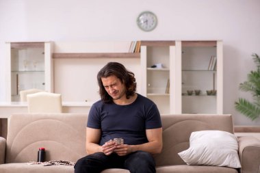 Evde acı çeken genç hasta adam.