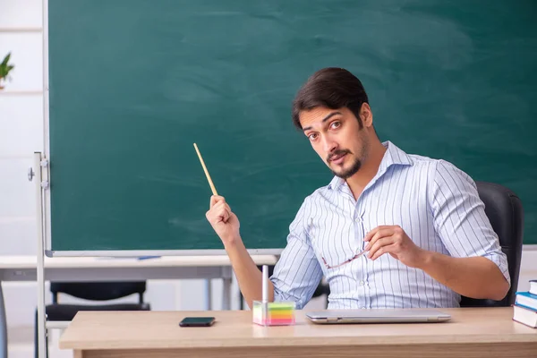 Joven profesor delante de pizarra —  Fotos de Stock