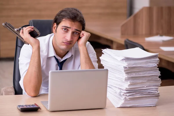 Jovem funcionário masculino infeliz com excesso de trabalho no escritório — Fotografia de Stock