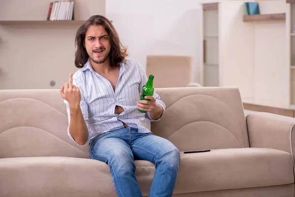 Joven bebiendo alcohol en casa — Foto de Stock