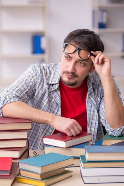 Junge männliche Schüler und zu viele Bücher im Klassenzimmer — Stockfoto