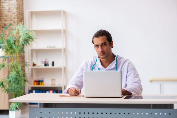 Junger Arzt macht sich Notizen in der Klinik — Stockfoto