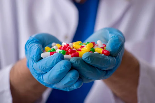 Joven médico masculino y demasiadas pastillas — Foto de Stock