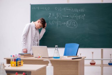 Öğrenci çocuk sınıfta kimya okuyor.