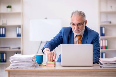 Ofiste oturan eski bir işadamı.