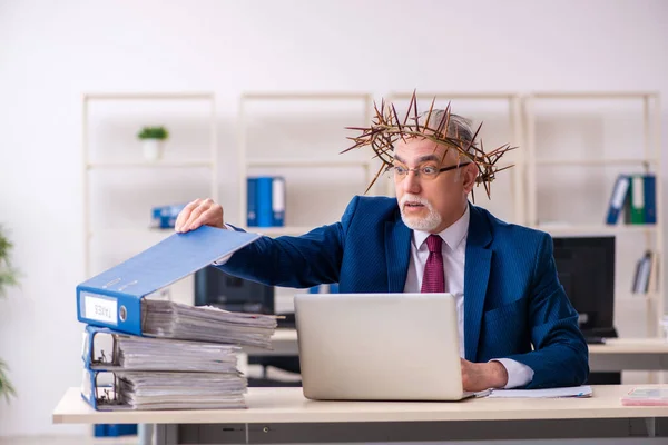 Alter männlicher Angestellter trägt stacheligen Kranz auf dem Kopf — Stockfoto