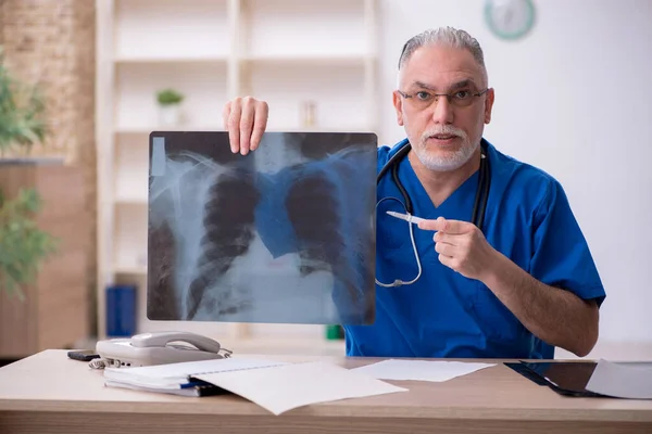 Gammal manlig röntgenläkare som arbetar på kliniken — Stockfoto