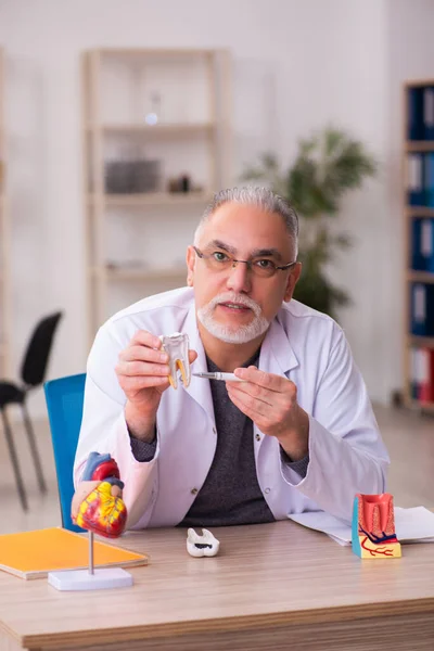 Vecchio dentista maschio insegnante seduto in classe — Foto Stock