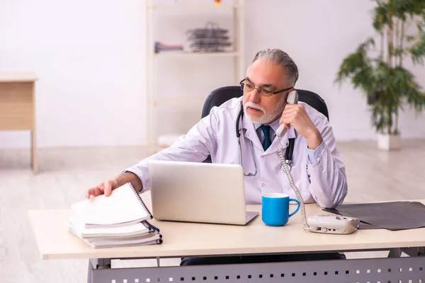 Médico idoso trabalhando na clínica — Fotografia de Stock