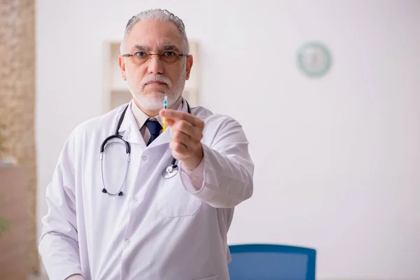 Velho médico do sexo masculino no conceito de vacinação — Fotografia de Stock