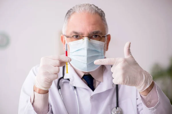 Old male doctor in vaccination concept — Stock Photo, Image