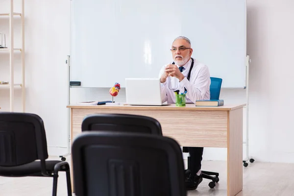 Oude mannelijke docent in de klas tijdens een pandemie — Stockfoto
