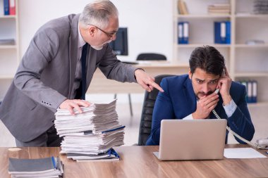 İki erkek çalışan ve ofiste çok fazla iş var.