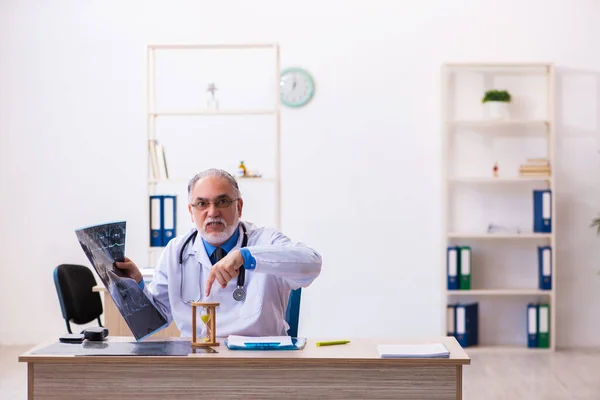 Velho médico radiologista masculino no conceito de gerenciamento de tempo — Fotografia de Stock