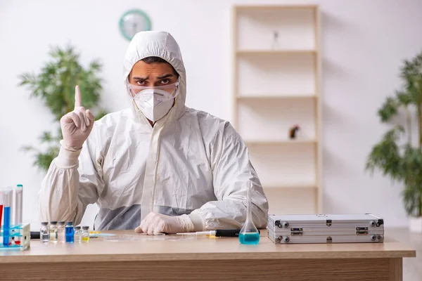 Jonge mannelijke chemicus werkt in het lab tijdens een pandemie — Stockfoto