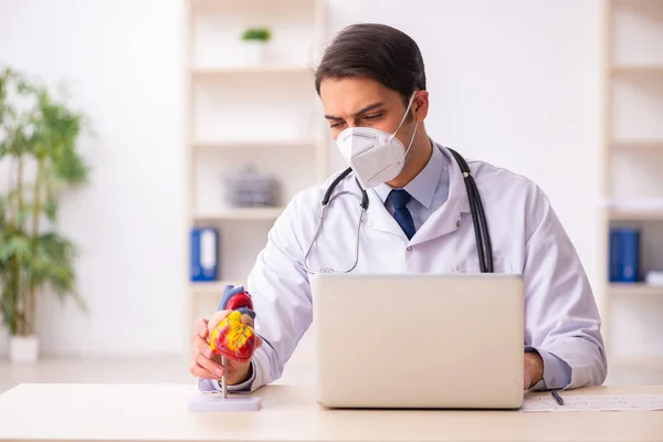 Jonge mannelijke cardioloog werkzaam in de kliniek tijdens de uitbreiding — Stockfoto