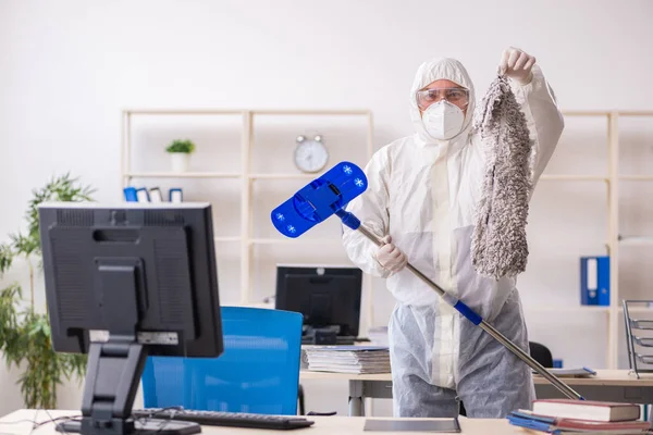 Velho empreiteiro masculino no conceito de desinfecção de escritório — Fotografia de Stock