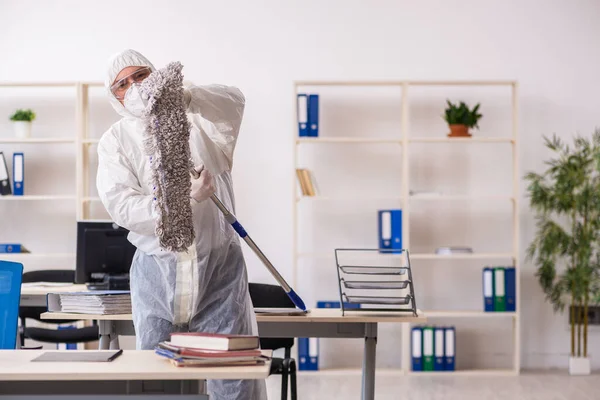 Velho empreiteiro masculino no conceito de desinfecção de escritório — Fotografia de Stock