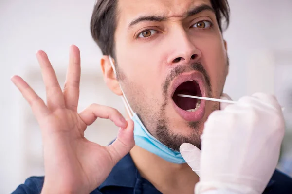 Junge männliche Patientin besucht alten Arzt während Pandemie — Stockfoto