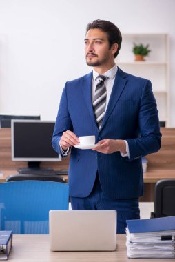 Molada kahve içen genç bir erkek.