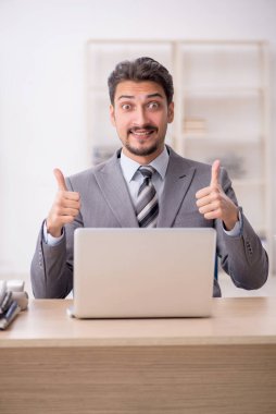 Ofisteki aşırı işten memnun olmayan genç bir erkek işçi.