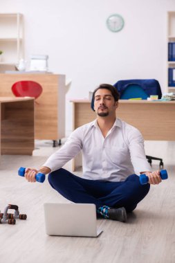 Mola sırasında spor yapan genç erkek çalışanlar.