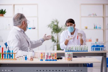 Laboratuvarda uyuşturucu sentezi konseptinde iki erkek kimyager.