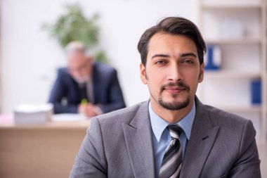 Ofiste çalışan iki erkek çalışan.