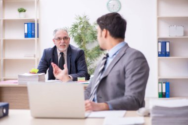 Ofiste çalışan iki erkek çalışan.