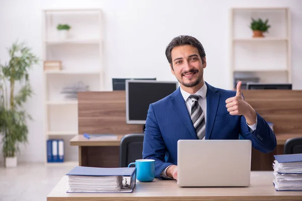 Joven empleado masculino y demasiado trabajo en la oficina — Foto de Stock